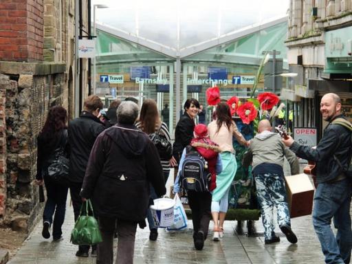 A photo of some people walking towards Barnsley Station with art
