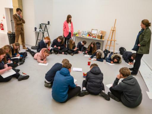 A group of teenagers seated on the floor during a workshop run by Claire Newton