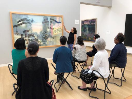 a woman discusses a picture at the Crocker Museum with a group of seated women
