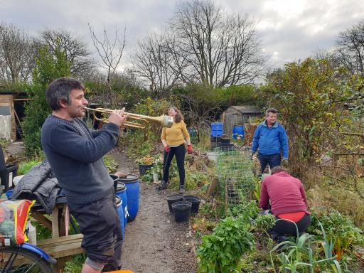 Man playing trumpet in allotment