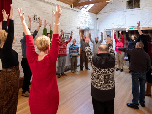 Group of people standing in a circle with their hands in the air