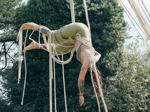 Two white women hanging from rope in mid air 