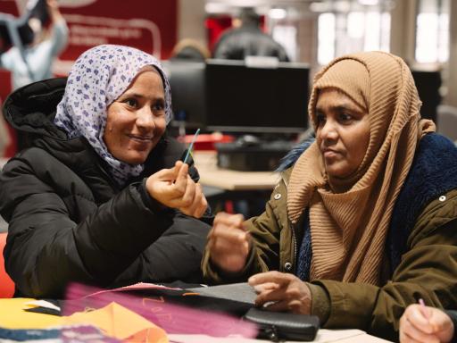 Two women in hijabs doing craft activity