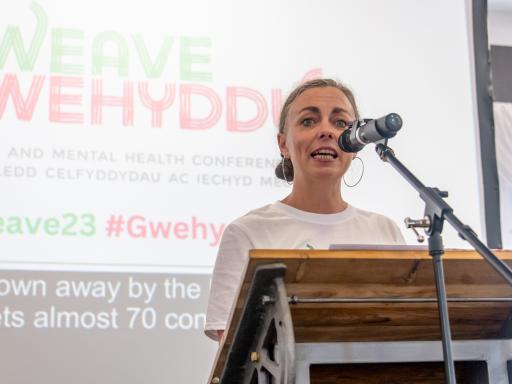 Blonde haired woman standing at podium